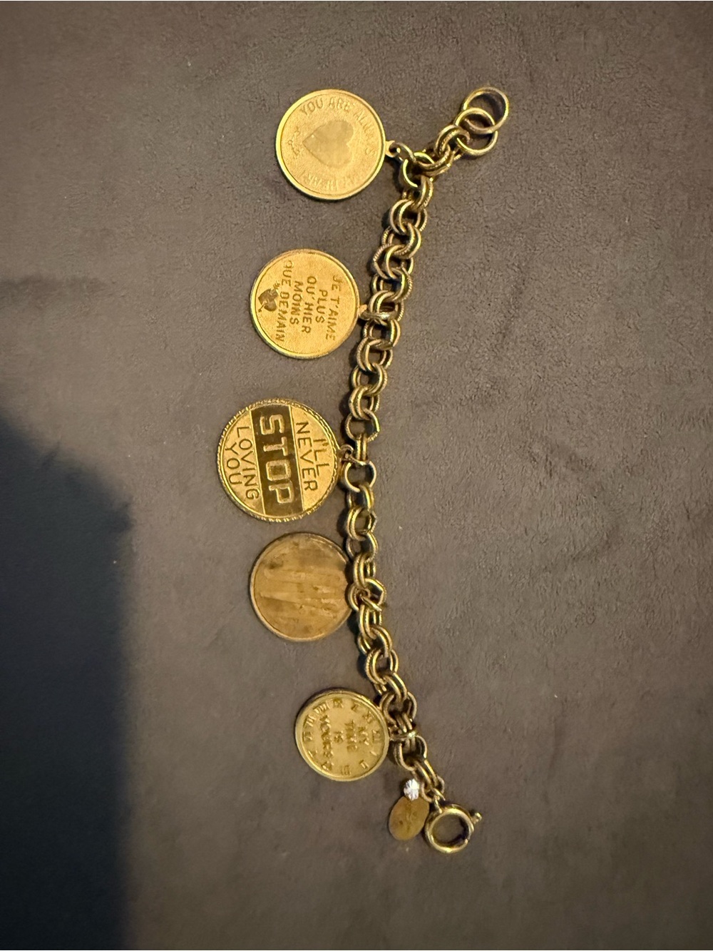 John Wind Studio gold plated charm bracelet features various love-themed coins.